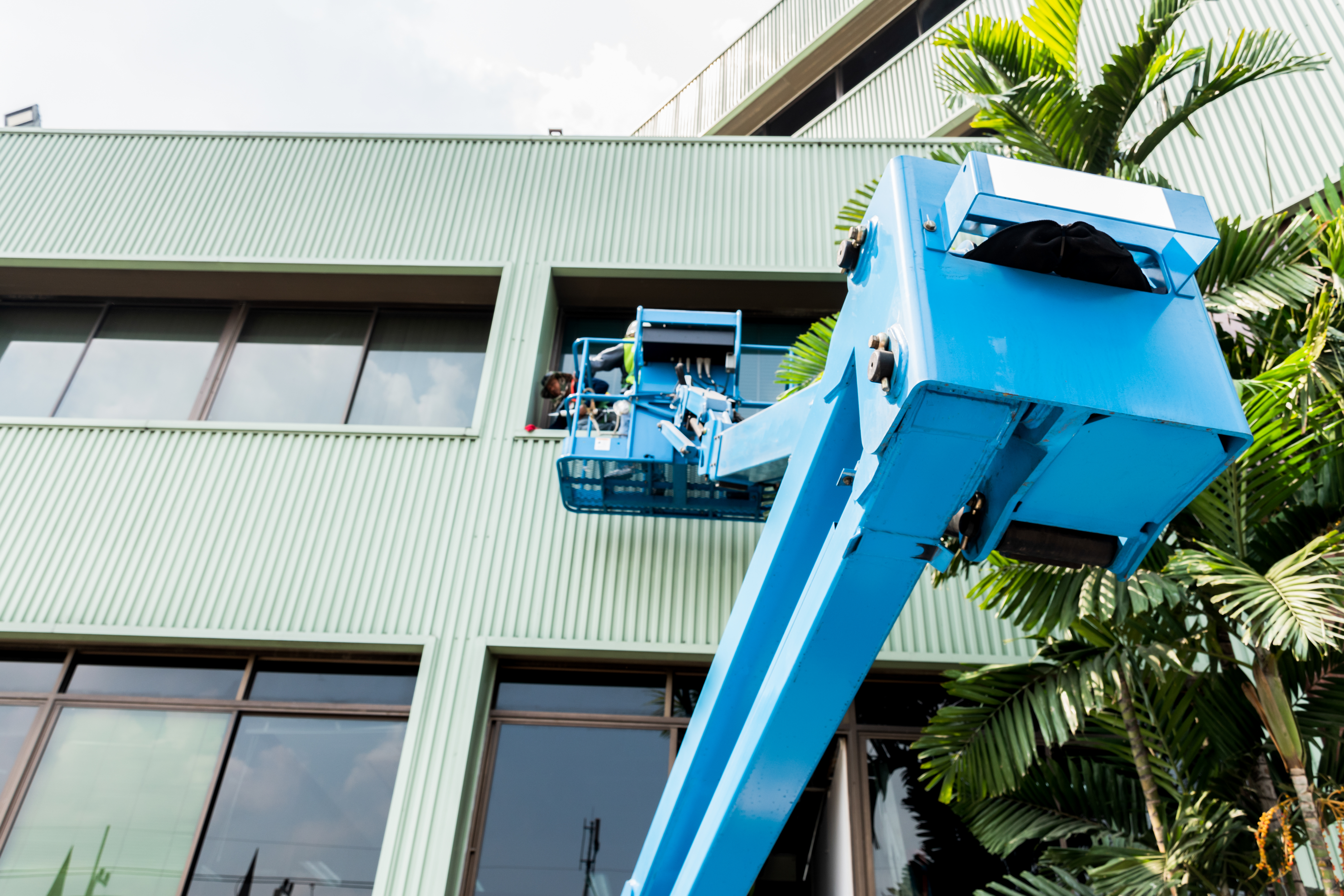 Building maintenance engineers painting a high-rise